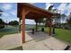 Wooden pavilion with picnic table overlooking green space and a basketball court at 15349 Oak Apple Ct, Winter Garden, FL 34787