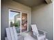 Relaxing patio featuring sliding glass doors and two comfortable chairs at 1558 Dalehurst Ln, Kissimmee, FL 34744