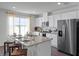 Bright kitchen featuring a granite island with seating and stainless steel appliances at 1562 Dalehurst Ln, Kissimmee, FL 34744