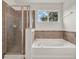 Modern bathroom featuring a glass shower and a luxurious soaking tub at 1744 Pine Ridge Dr, Davenport, FL 33896