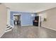 View of the living room featuring blue accent wall and gray wood floors leading to the staircase at 1744 Pine Ridge Dr, Davenport, FL 33896
