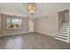 Bright living room featuring gray wood floors, a chandelier, and a staircase to the upper level at 1744 Pine Ridge Dr, Davenport, FL 33896