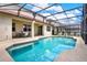 Sparkling in-ground pool with a screened enclosure, surrounded by a patio and outdoor seating, perfect for relaxation and entertainment at 1744 Pine Ridge Dr, Davenport, FL 33896