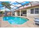 Refreshing pool area featuring a screened enclosure, ample seating, and a view of the home's backyard, ideal for leisure and recreation at 1744 Pine Ridge Dr, Davenport, FL 33896