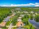 An aerial view shows houses in a wooded neighborhood, some with solar panels and pools, near a pond at 1846 Branchwater Trl, Orlando, FL 32825