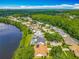 An aerial view of a lakeside community with mature trees, pools, solar panels, and well-kept landscaping at 1846 Branchwater Trl, Orlando, FL 32825