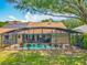 Home exterior showcasing a screened-in pool area, solar panels, and lush landscaping at 1846 Branchwater Trl, Orlando, FL 32825
