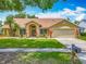 Beautifully landscaped front yard leading to a well-maintained single-story home with a two-car garage at 1846 Branchwater Trl, Orlando, FL 32825