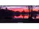 Scenic view of a lake at sunset, with the sky ablaze in hues of pink and orange, reflecting in the water at 1846 Branchwater Trl, Orlando, FL 32825