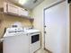 Laundry room with washer, dryer, overhead storage cabinets, and convenient access to the exterior at 1846 Branchwater Trl, Orlando, FL 32825