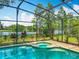Sparkling blue pool with an attached spa and screened enclosure overlooking a tranquil lake at 1846 Branchwater Trl, Orlando, FL 32825