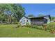 View of home's exterior and backyard, with green lawn and surrounding vegetation at 2045 South St, Oviedo, FL 32765