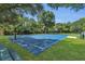 Community basketball court on a sunny day with blue painted surface and green surrounding grass at 2045 South St, Oviedo, FL 32765