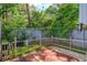 Fenced backyard with red wooden deck, artificial turf, and lush landscaping at 209 Sweet Gum Way, Longwood, FL 32779