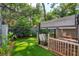 Fenced backyard featuring a wooden deck with awning, artificial turf, and green foliage at 209 Sweet Gum Way, Longwood, FL 32779