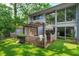 Backyard with wooden deck, awning, lush landscaping, and artificial turf at 209 Sweet Gum Way, Longwood, FL 32779