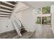 Open entryway with hardwood floors, staircase, and light-filled windows with views to exterior landscaping at 209 Sweet Gum Way, Longwood, FL 32779