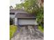 Charming home featuring an attached two-car garage and a well-maintained driveway and mature trees at 209 Sweet Gum Way, Longwood, FL 32779