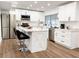 Modern kitchen featuring white cabinetry, stainless steel appliances, granite countertops, and breakfast bar seating at 209 Sweet Gum Way, Longwood, FL 32779
