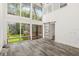 Open living area features high ceilings, floor-to-ceiling windows, and a sliding door to the deck at 209 Sweet Gum Way, Longwood, FL 32779