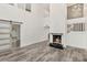 Bright living room with fireplace, gray wood floors, and sliding barn door at 209 Sweet Gum Way, Longwood, FL 32779