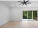 Minimalist bedroom with light wood floors, modern ceiling fan, and a large sliding glass door at 2137 Brighton Ln, Orlando, FL 32817