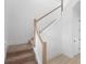 Bright staircase featuring wood and white banisters and tan carpeted steps at 2137 Brighton Ln, Orlando, FL 32817