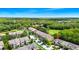 Wide aerial shot of neighborhood townhomes with surrounding trees and a serene pond at 2157 Cypress Villas Dr, Orlando, FL 32825
