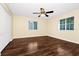 Comfortable bedroom featuring hardwood floors, ceiling fan, and natural lighting from two windows at 2157 Cypress Villas Dr, Orlando, FL 32825