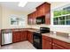 Well-equipped kitchen with dark wood cabinets, black appliances, and tiled flooring at 2157 Cypress Villas Dr, Orlando, FL 32825