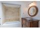 This renovated bathroom features a wood vanity, round mirror and updated shower tiling at 2171 Chippewa Trl, Maitland, FL 32751