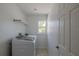 Bright laundry room with a window, modern machines, and white walls at 2171 Chippewa Trl, Maitland, FL 32751