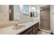 Bathroom features a double sink vanity, mirror and walk-in shower with tile at 2316 Irlo Dr, Kissimmee, FL 34741