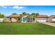 Charming single-story home with a bright blue door, lush lawn, and mature landscaping at 2316 Irlo Dr, Kissimmee, FL 34741