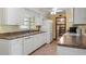 Bright kitchen featuring white cabinets, tile flooring, and an adjacent pantry at 2316 Irlo Dr, Kissimmee, FL 34741