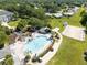 A high-angle aerial view showcases a luxurious community pool, clubhouse, and well-manicured landscaping at 25409 Waterbrook Ct, Leesburg, FL 34748