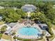 Aerial view of community pool, lush landscaping, and clubhouse in a tranquil neighborhood at 25409 Waterbrook Ct, Leesburg, FL 34748