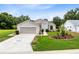 Charming single-Gathering home boasts a well-manicured lawn and beautiful landscaping, complemented by a driveway and 2-car garage at 25409 Waterbrook Ct, Leesburg, FL 34748