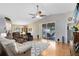 Bright living room boasts hardwood floors, vaulted ceiling, modern ceiling fan, and sliding door access to lanai and pool at 25409 Waterbrook Ct, Leesburg, FL 34748