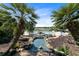 View of community pool, a small stone bridge, and lush greenery with tropical plants and palm trees at 25409 Waterbrook Ct, Leesburg, FL 34748