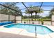 Inviting in-ground pool in a screened enclosure, surrounded by lush landscaping at 25409 Waterbrook Ct, Leesburg, FL 34748