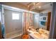 Cozy bathroom featuring a shower-tub combo, white tile and a warm vanity with attractive fixtures at 2708 Burton Ln, Orlando, FL 32817