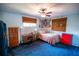 A cozy bedroom with a ceiling fan, blue carpet, and a bed at 2708 Burton Ln, Orlando, FL 32817