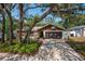 Alluring one-story home showcasing a lush front yard, a driveway, and a two-car garage, shaded by trees at 2708 Burton Ln, Orlando, FL 32817