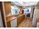 Cozy kitchen features wood cabinetry, a double sink, and a pass-through to the living area, creating an open feel at 2708 Burton Ln, Orlando, FL 32817