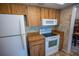 The kitchen has wood cabinets, a white oven range, microwave, and refrigerator at 2708 Burton Ln, Orlando, FL 32817