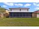 Exterior view of the rear of the house showing a large, screened lanai and spacious yard at 2724 Amanda Kay Way, Kissimmee, FL 34744