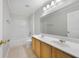 Bathroom featuring a double sink vanity, tiled flooring, tub/shower combo, and bright lighting at 2724 Amanda Kay Way, Kissimmee, FL 34744