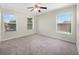 Bright bedroom featuring neutral paint, soft carpet, ceiling fan, and windows with outside views at 2724 Amanda Kay Way, Kissimmee, FL 34744