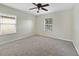 Cozy bedroom with neutral walls, soft carpet, ceiling fan, and bright, natural lighting at 2724 Amanda Kay Way, Kissimmee, FL 34744